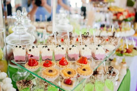 Catering at a luxury event with a wide choice of delicious gourmet desserts displayed on a long buffet table